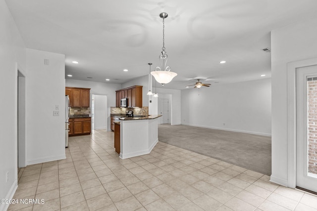 kitchen with backsplash, hanging light fixtures, ceiling fan, light tile patterned floors, and stainless steel appliances