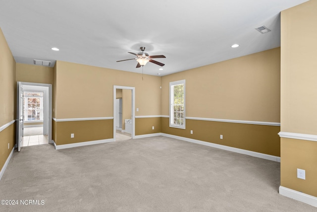 empty room featuring ceiling fan and light colored carpet