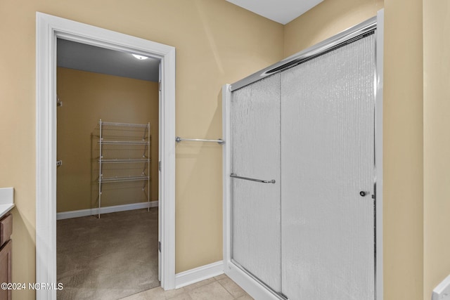 bathroom featuring tile patterned floors, vanity, and a shower with door