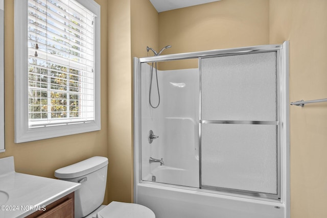 full bathroom with shower / bath combination with glass door, vanity, and toilet