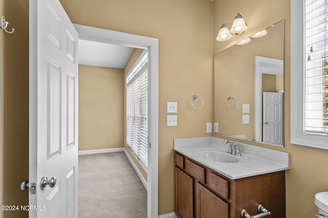 bathroom featuring vanity, toilet, and plenty of natural light