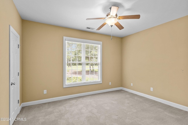 spare room with ceiling fan and light colored carpet