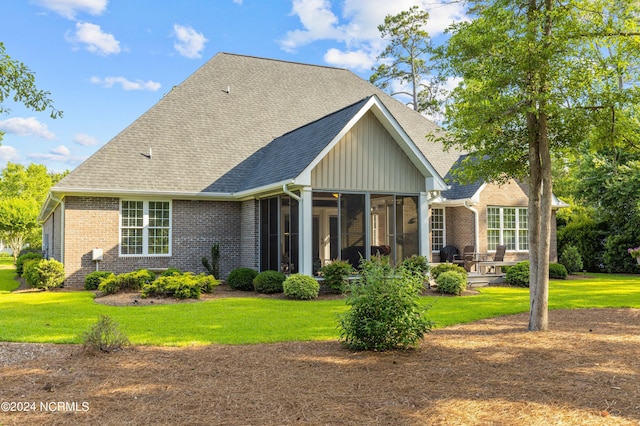 back of house featuring a lawn and a sunroom