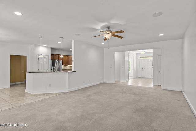 unfurnished living room with ceiling fan and light carpet