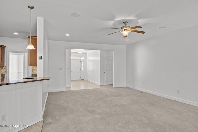 unfurnished living room with ceiling fan and light carpet