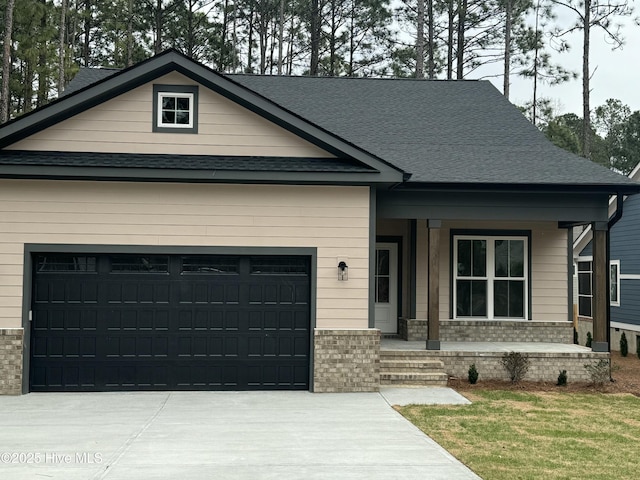 craftsman inspired home with a porch, an attached garage, brick siding, and driveway