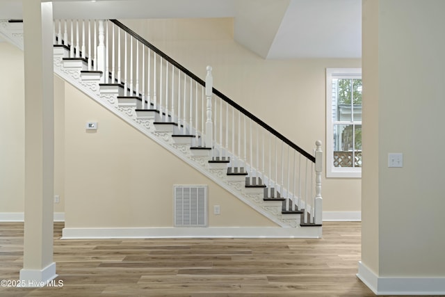 stairs featuring hardwood / wood-style floors