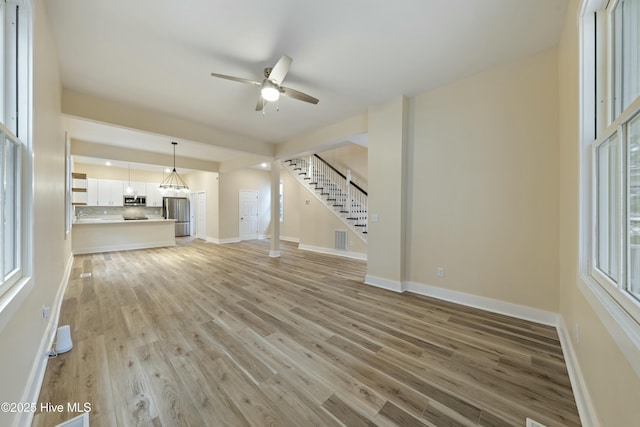 unfurnished living room with light hardwood / wood-style floors and ceiling fan