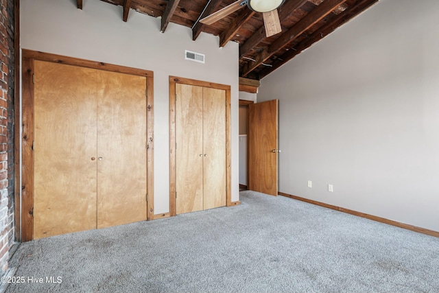 unfurnished bedroom with wood ceiling, beam ceiling, high vaulted ceiling, carpet, and two closets