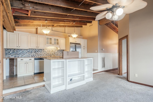 kitchen featuring appliances with stainless steel finishes, pendant lighting, vaulted ceiling with beams, a center island, and light colored carpet