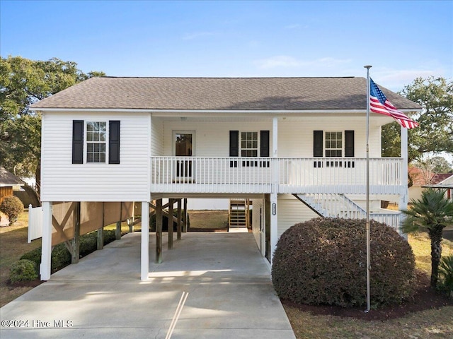 raised beach house with a porch and a carport