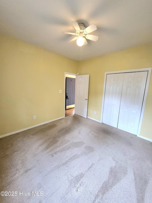 unfurnished bedroom with carpet flooring, ceiling fan, and a closet