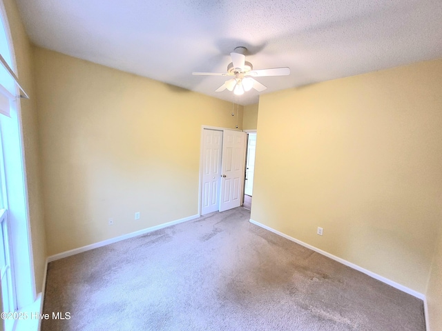 carpeted spare room with ceiling fan and a textured ceiling