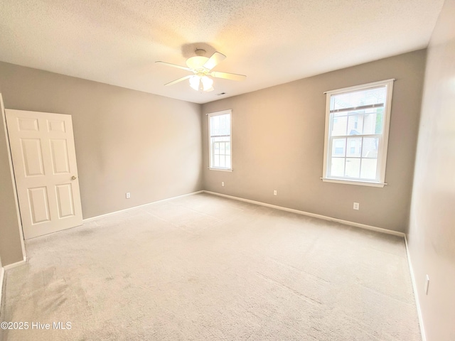 unfurnished room with a textured ceiling, ceiling fan, a healthy amount of sunlight, and light carpet