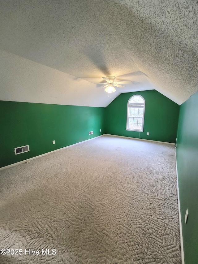 additional living space featuring carpet flooring, ceiling fan, a textured ceiling, and lofted ceiling