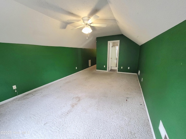 additional living space featuring carpet flooring, lofted ceiling, ceiling fan, and a textured ceiling