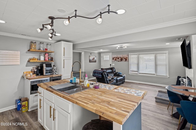 kitchen with sink, wood-type flooring, and a kitchen island with sink