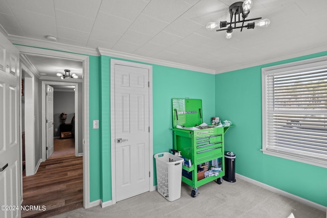 playroom with carpet, ornamental molding, and a notable chandelier