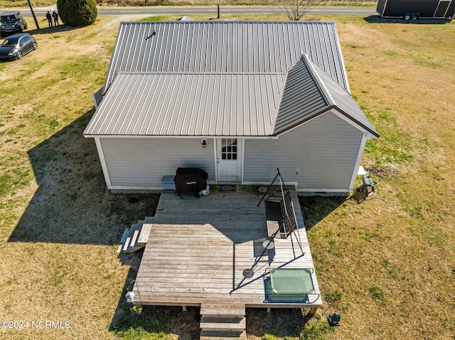 back of house featuring a lawn and a wooden deck