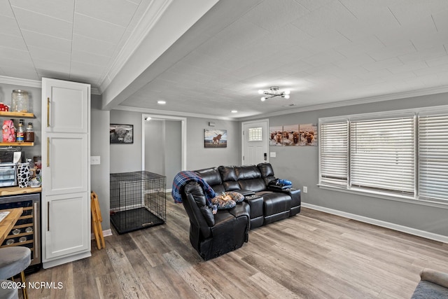 living room featuring bar, wood-type flooring, ornamental molding, and beverage cooler