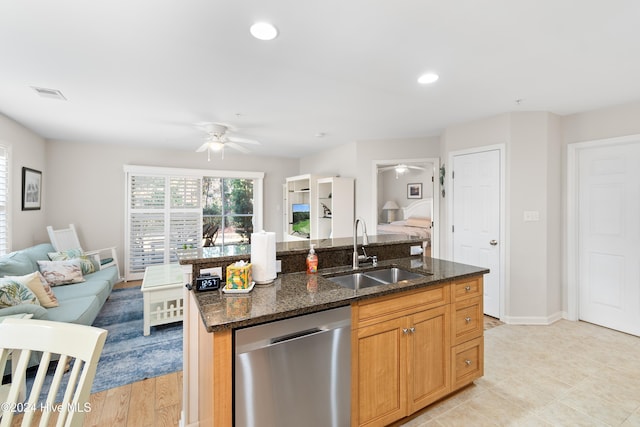 kitchen with sink, dark stone countertops, dishwasher, light hardwood / wood-style floors, and an island with sink