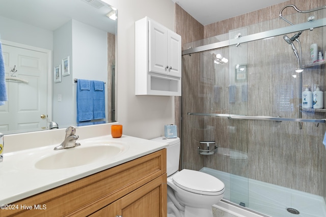 bathroom featuring vanity, an enclosed shower, and toilet