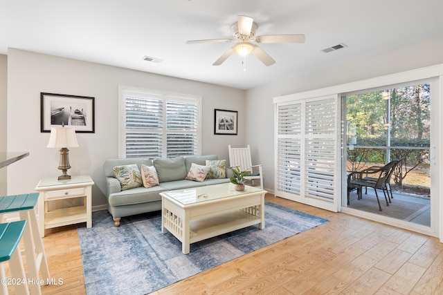 living room with light hardwood / wood-style flooring and ceiling fan