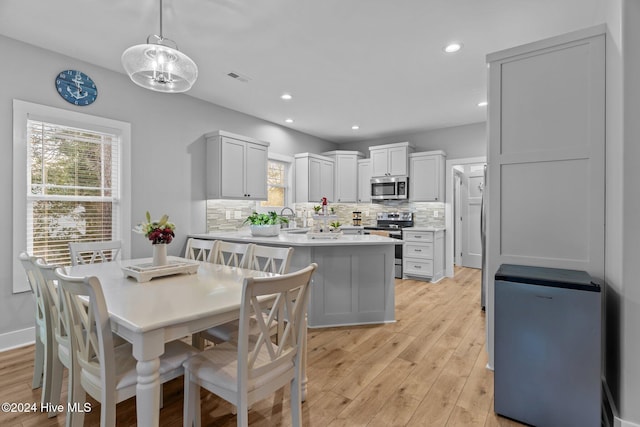 dining area with light hardwood / wood-style flooring and sink