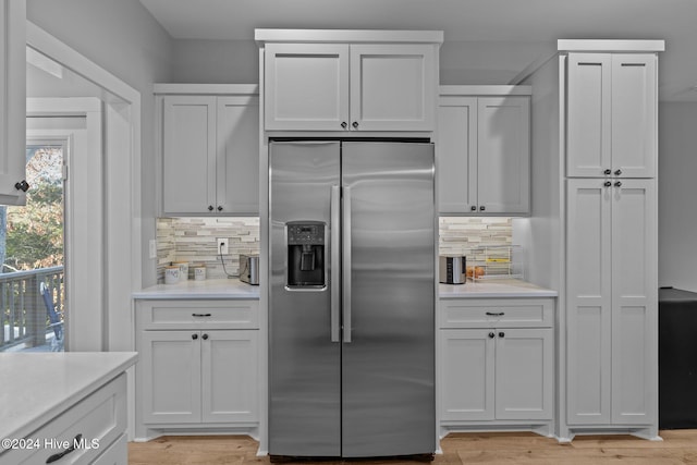 kitchen featuring white cabinetry, stainless steel fridge, and tasteful backsplash