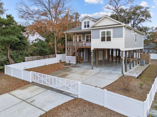 view of front of property featuring a carport, a porch, and cooling unit