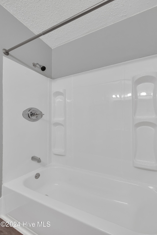 bathroom featuring shower / bathing tub combination and a textured ceiling