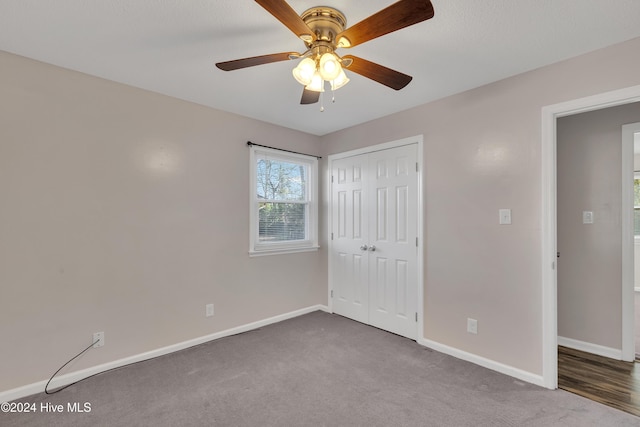 unfurnished bedroom with carpet, a closet, and ceiling fan