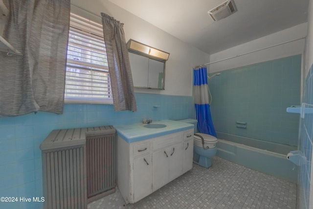 full bathroom with shower / bath combo, tile walls, tile patterned flooring, vanity, and toilet