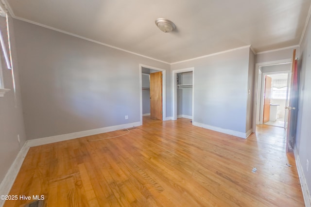 unfurnished bedroom with crown molding, a closet, and light hardwood / wood-style flooring