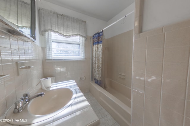 bathroom featuring sink, tile patterned flooring, tile walls, and shower / bath combo