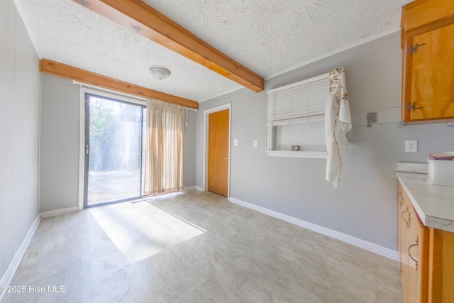 interior space featuring beamed ceiling and a textured ceiling