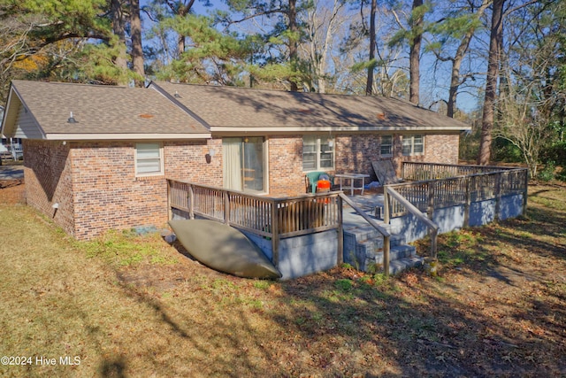 rear view of house with a yard and a deck