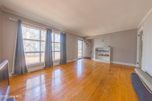 unfurnished living room featuring crown molding, hardwood / wood-style flooring, and a healthy amount of sunlight