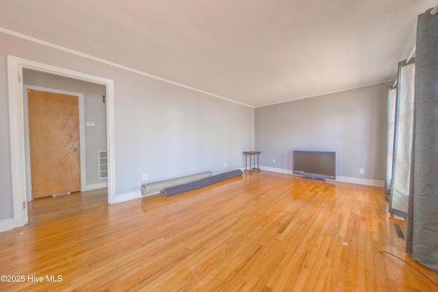 unfurnished living room with crown molding and hardwood / wood-style floors