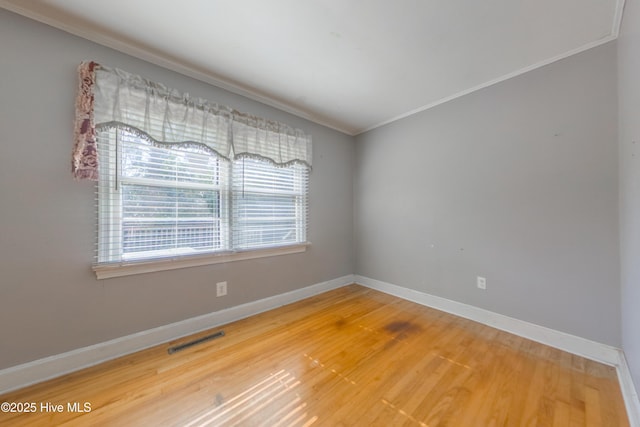 spare room with hardwood / wood-style floors and ornamental molding