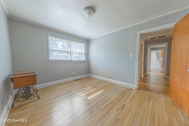 spare room with crown molding and light wood-type flooring