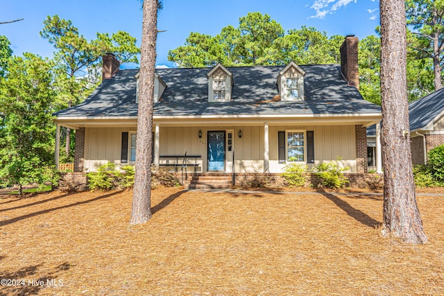 cape cod-style house featuring covered porch