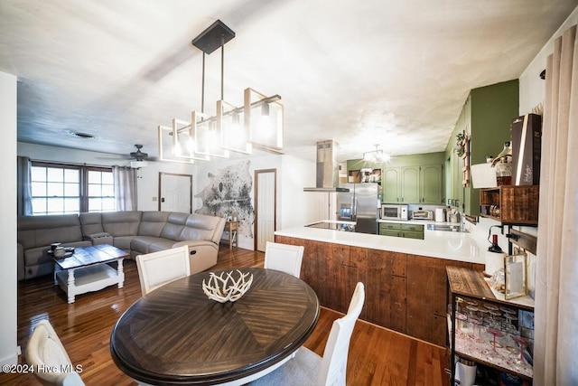 dining area featuring ceiling fan, sink, and dark hardwood / wood-style floors