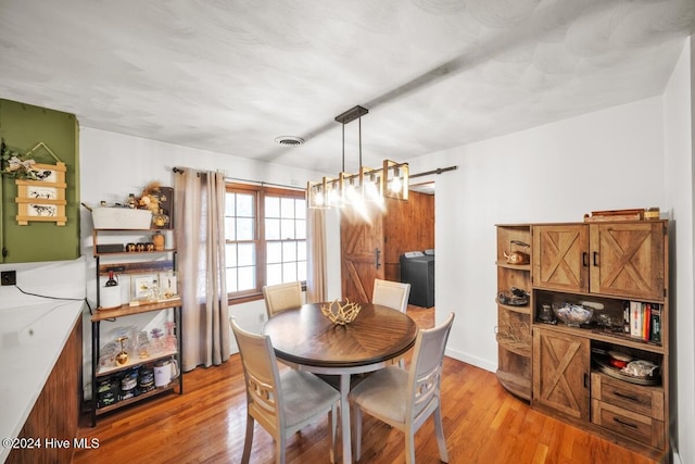 dining area with washer / clothes dryer and light hardwood / wood-style flooring