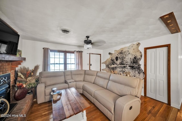 living room with ceiling fan, dark hardwood / wood-style flooring, and a fireplace