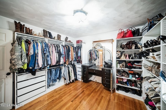 walk in closet with hardwood / wood-style floors