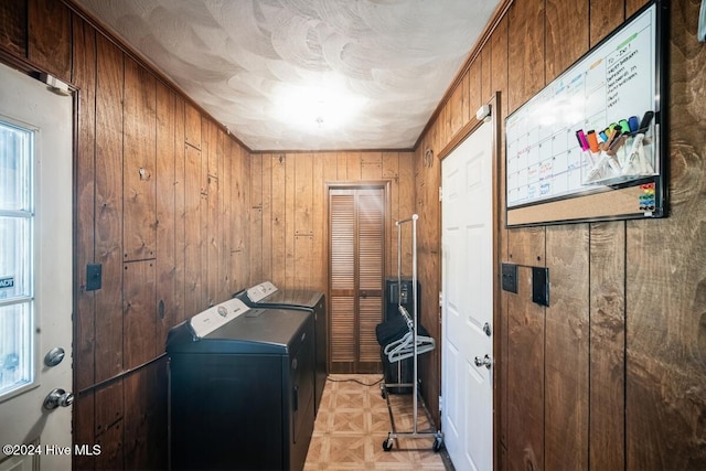 laundry room featuring light parquet floors, ornamental molding, wood walls, and independent washer and dryer