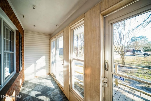 doorway to outside with plenty of natural light and ornamental molding