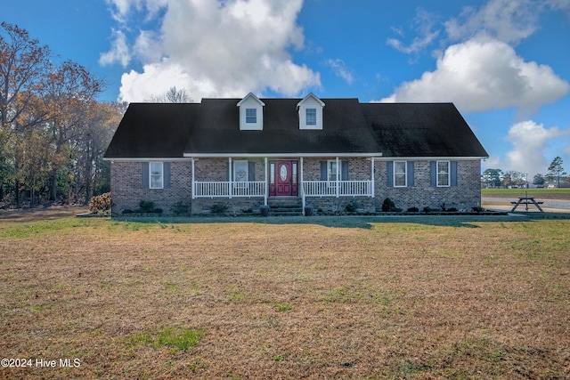 cape cod house with covered porch and a front lawn