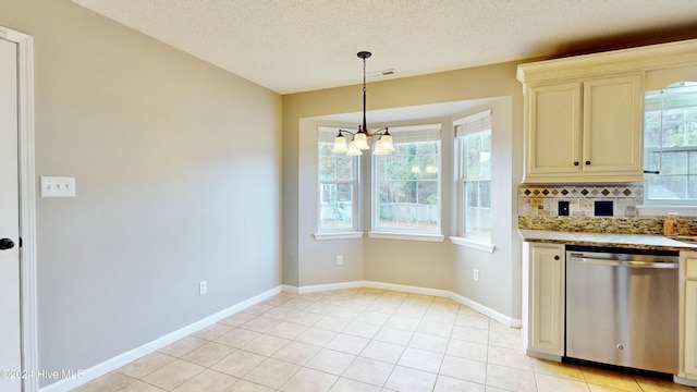 kitchen featuring stainless steel dishwasher, plenty of natural light, decorative backsplash, and cream cabinetry